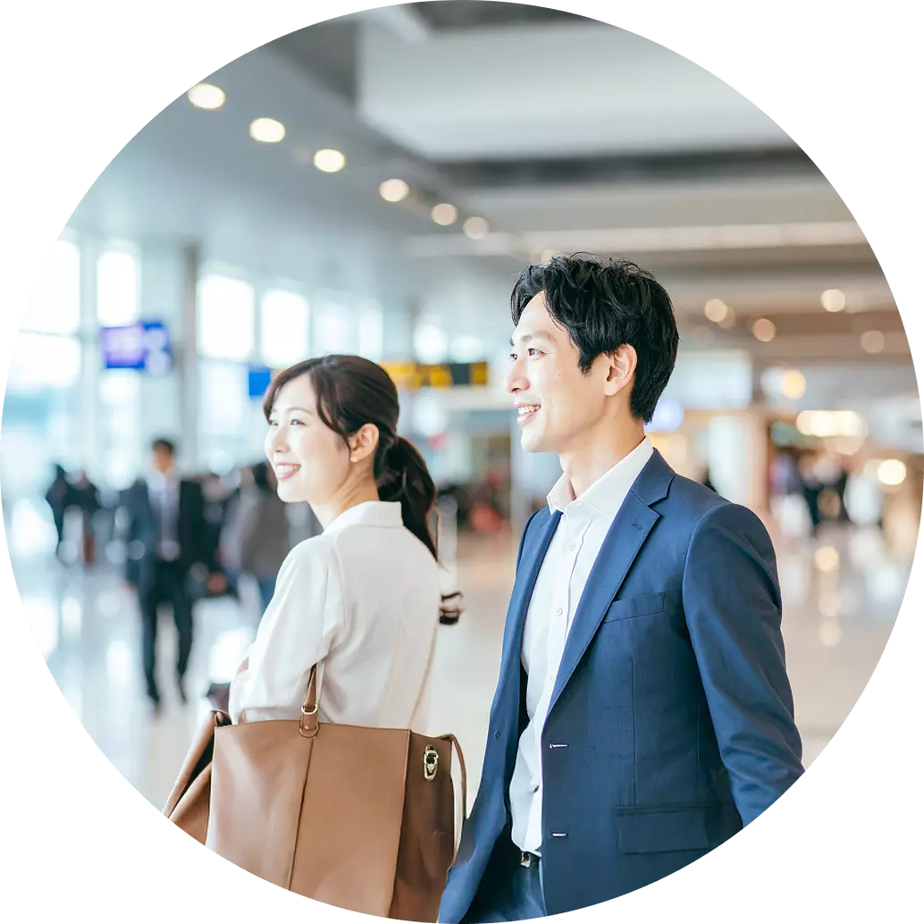 空港のロビーで、スーツを着た男性と女性が並んで立っている画像